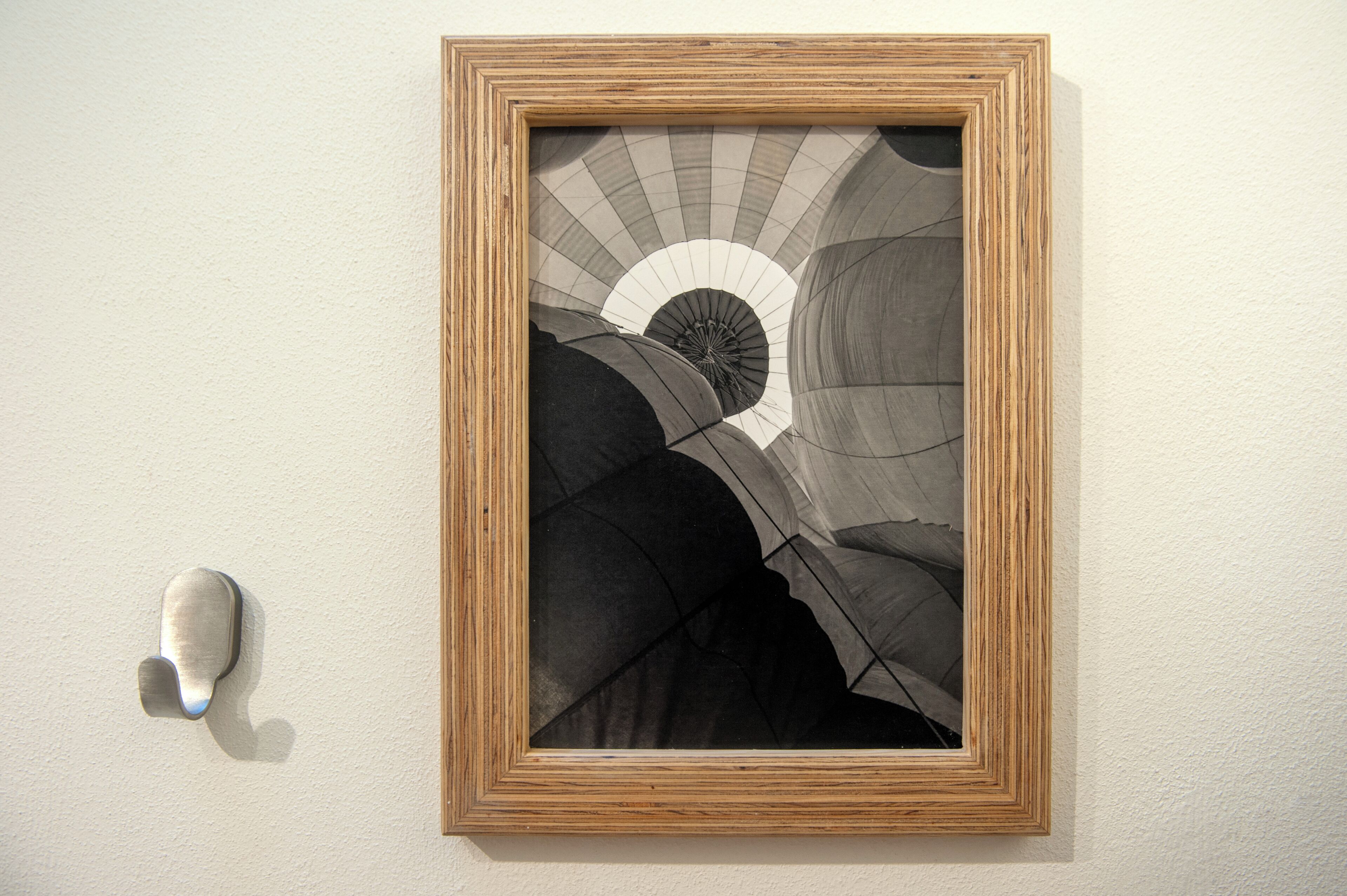 A framed artwork depicting a spiral staircase against a plain wall.