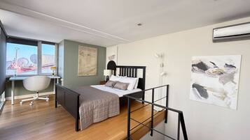 Ein modernes Schlafzimmer mit Bett, Schreibtisch, Stuhl und Kunstwerk.