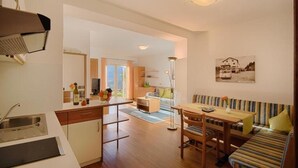 Een moderne keuken met een eethoek, een bank en een groot raam.