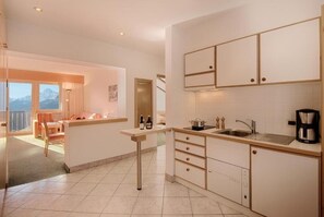 A modern kitchen with a built-in dishwasher, a coffee maker, and a view of the mountains. - Apartment Maria - Apartment with fantastic mountain views (Schenna)