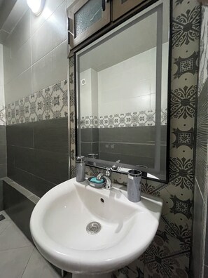 Chuveiro, toalhas de banho, sabonete, papel higiênico