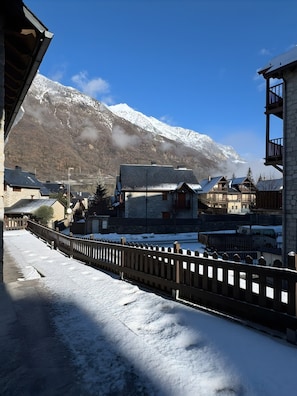 A snow-covered street with buildings and a mountain in the background. - Casa Arguis Country House with Mountain Views, Wi-Fi, and Air Conditioning (Eriste)