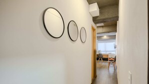 Ein Flur mit drei runden Spiegeln an der Wand, der zu einem Essbereich mit Tisch und Stühlen führt.