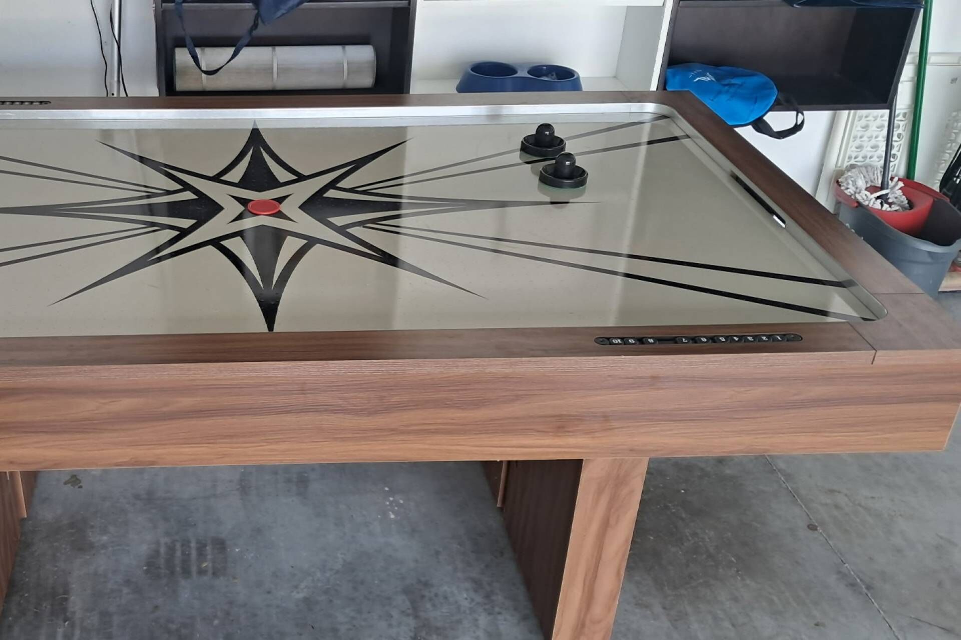 Ein Tisch mit Glasplatte und Holzrahmen, mit einem Sterndesign und roter Mitte.