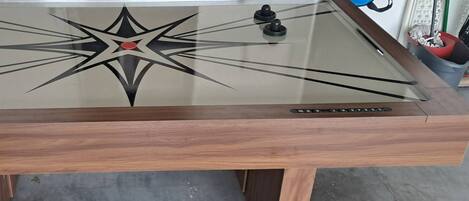 Ein Tisch mit Glasplatte und Holzrahmen, mit einem Sterndesign und roter Mitte.