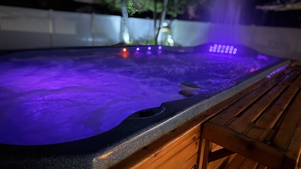 Un jacuzzi con banca de madera y una fuente de agua.