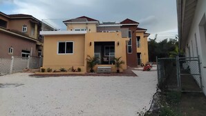 Ein modernes, zweistöckiges Haus mit flachem Dach und kleinem Vorgarten.