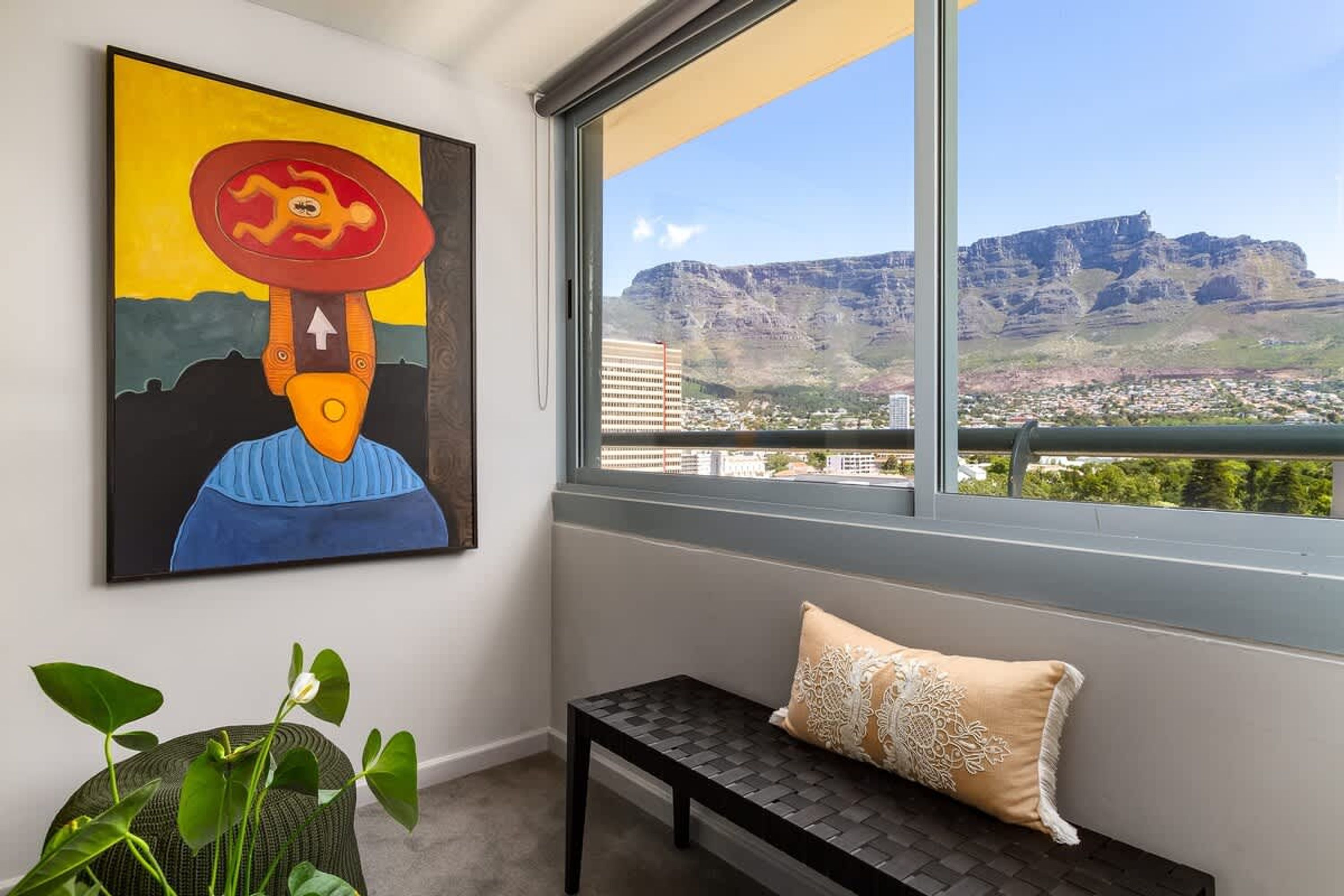 A room with a large window overlooking a mountain and cityscape.
