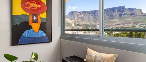 A room with a large window overlooking a mountain and cityscape.