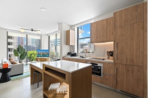 Una cocina moderna con armarios de madera, una isla central y un área de comedor con sofá y mesa de centro.