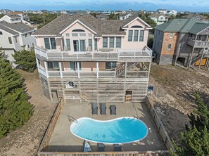 Ein mehrstöckiges Haus mit Swimmingpool, Balkonen und Blick auf die Nachbarschaft.