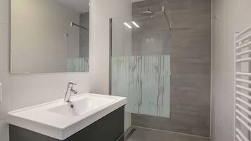 Een douche, een haardroger, handdoeken, toiletpapier