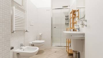 Een moderne badkamer met een douche, wc en wastafel.