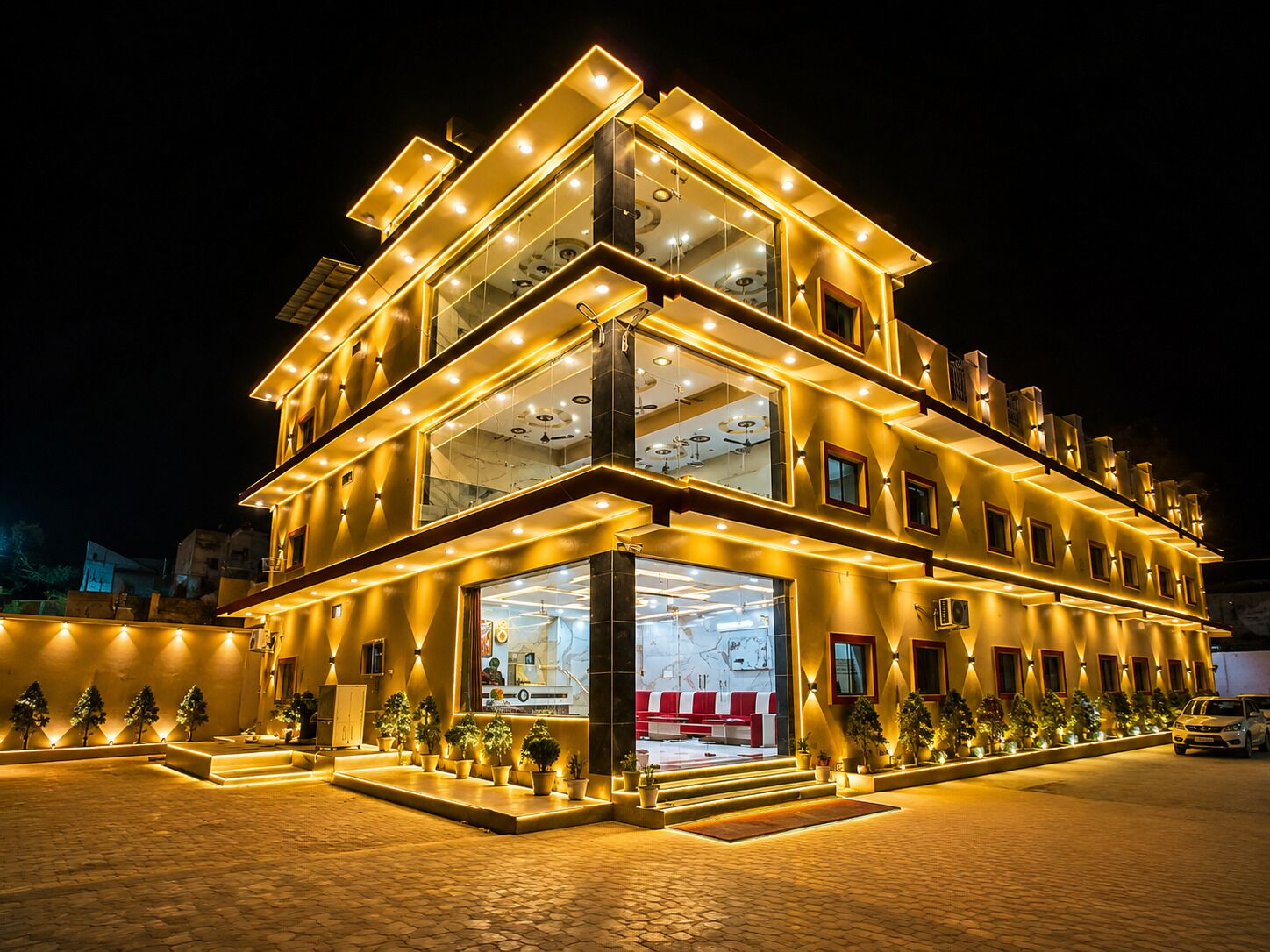 A multi-story hotel with a modern design, featuring a prominent glass facade and a well-lit entrance.