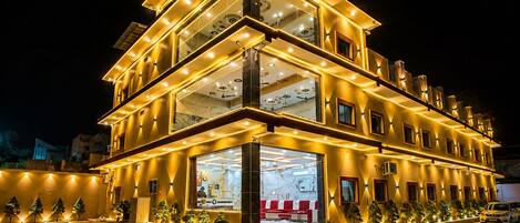 A multi-story hotel with a modern design, featuring a prominent glass facade and a well-lit entrance.