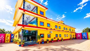 Un immeuble à plusieurs étages, doté d’une façade jaune vif, de grandes fenêtres et d’un toit plat.