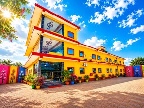 A multi-story building with a yellow facade, large windows, and a red roof. - Shree Venkatesh Niliyam 300 M Ram Temple (Ayodhya)