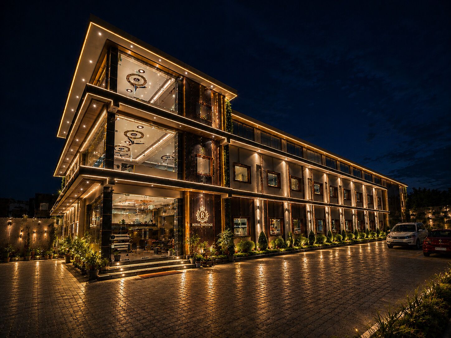 A multi-story hotel with a modern design, featuring a prominent entrance with glass doors and a well-lit facade.