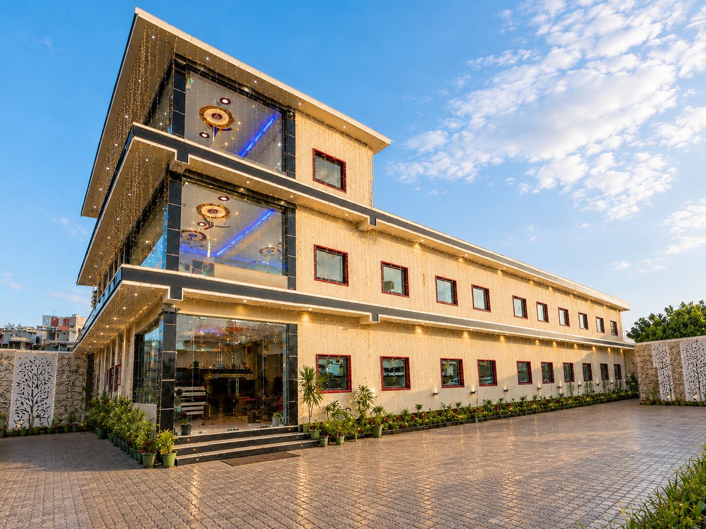 Een modern gebouw met een glazen gevel, meerdere ramen en een verharde binnentuin.