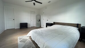 Una camera da letto con un letto, una ventola a soffitto, un armadio e un termosifone.