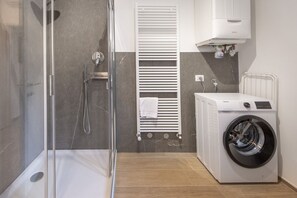 Een douche, een bidet, handdoeken, toiletpapier