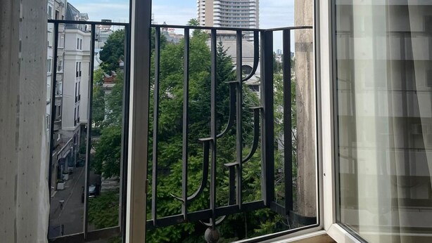A view from a balcony with a metal railing, a clear sky, and a building labeled "GRAND HOTEL" in the background. - Charming Studio  Bucharest City Center! (București)