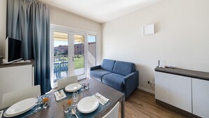 A modern kitchen with a dining area, a sofa, and a TV. - San Sivino 108 Lake View with Pool (Manerba del Garda)