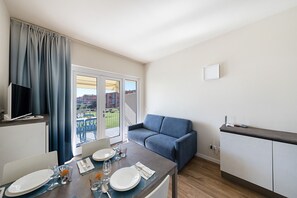 A modern kitchen with a dining area, a sofa, and a TV. - San Sivino 108 Lake View with Pool (Manerba del Garda)