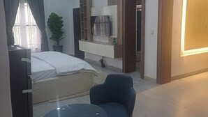Een moderne slaapkamer met een bed, nachtkastje en stoel.