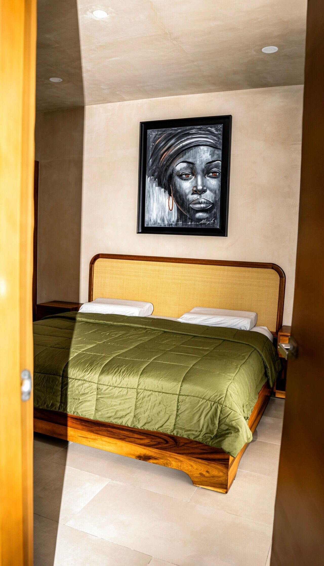 Un dormitorio con una cama, una obra de arte enmarcada en la pared y un cabecero de madera.