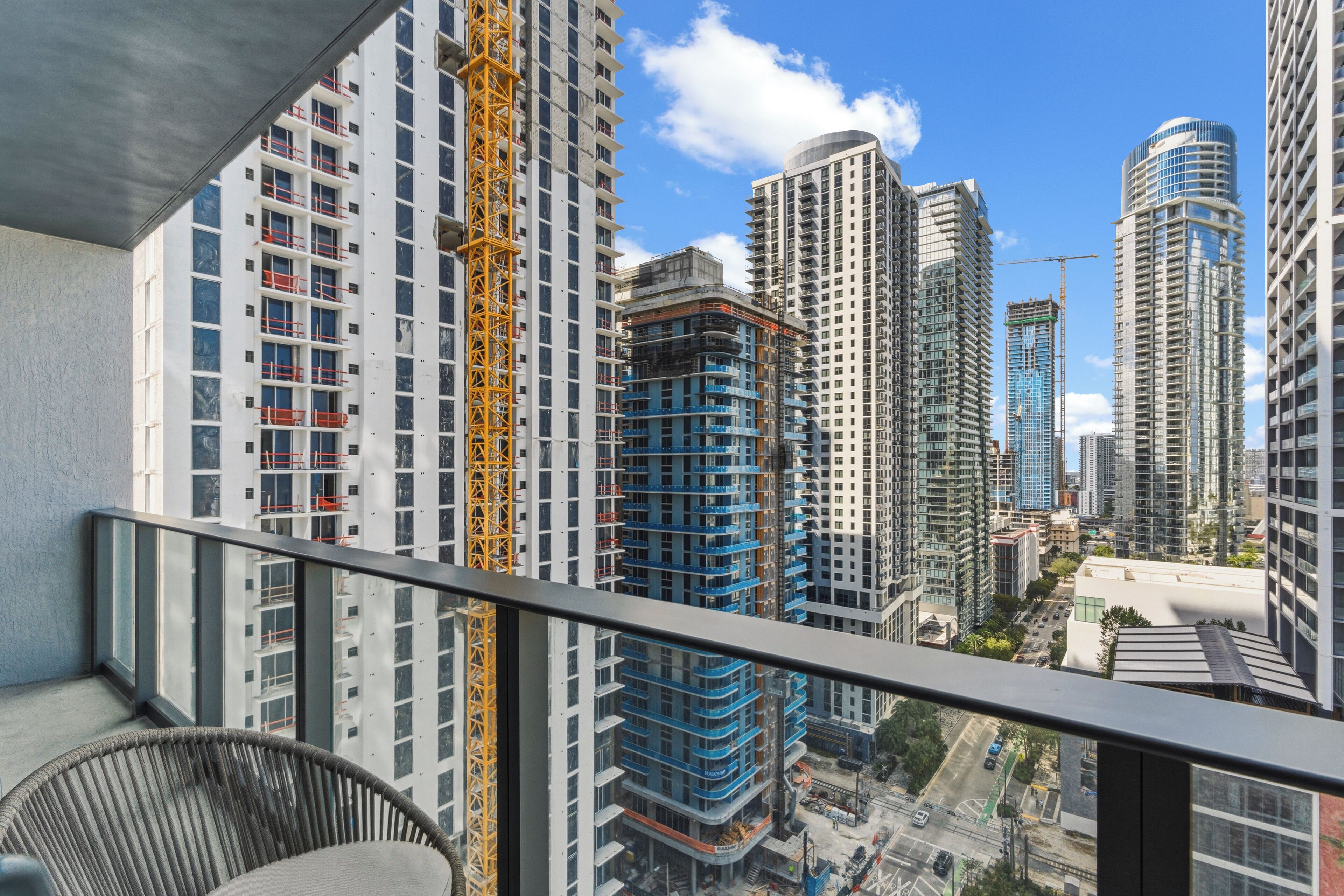 A high-rise building with multiple floors, a construction crane, and a view of the surrounding cityscape.