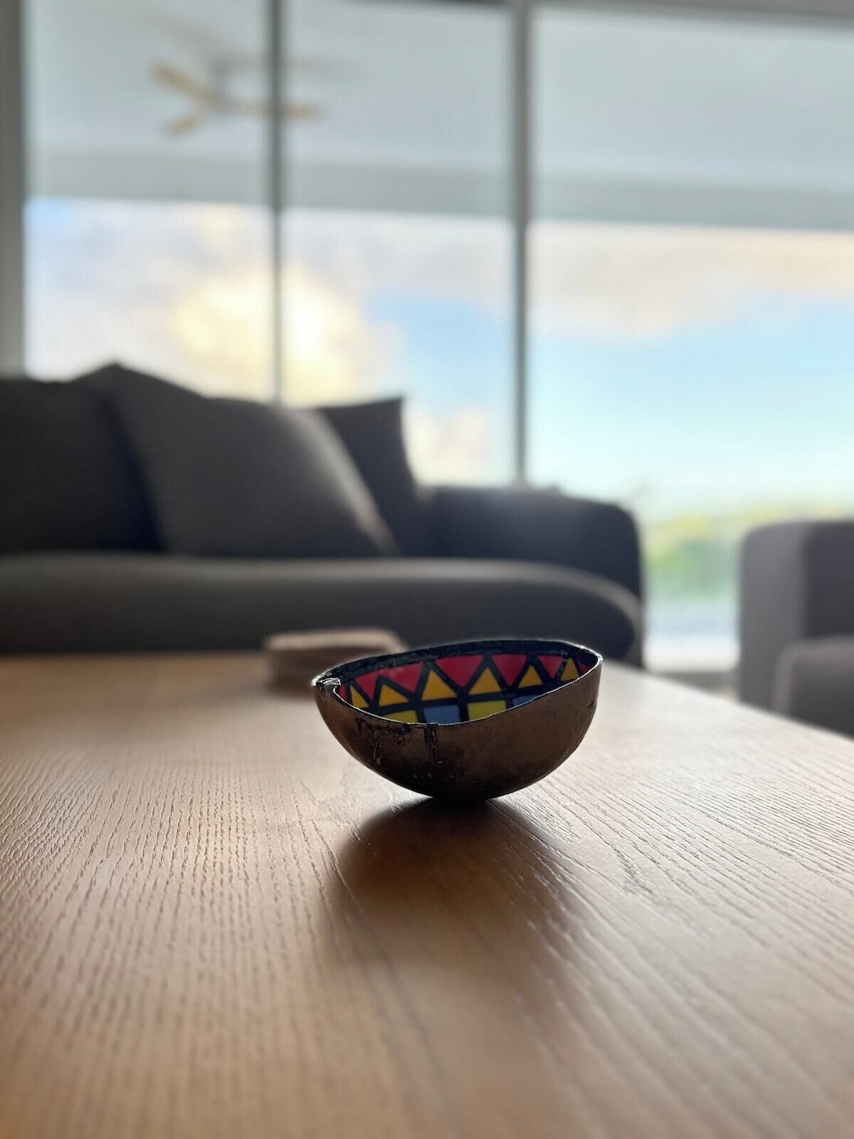 A wooden table with a colorful bowl in the foreground.