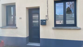 A building with a black door, a window, and a mailbox.