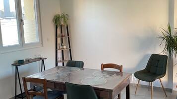 A dining area with a table, chairs, and a potted plant.