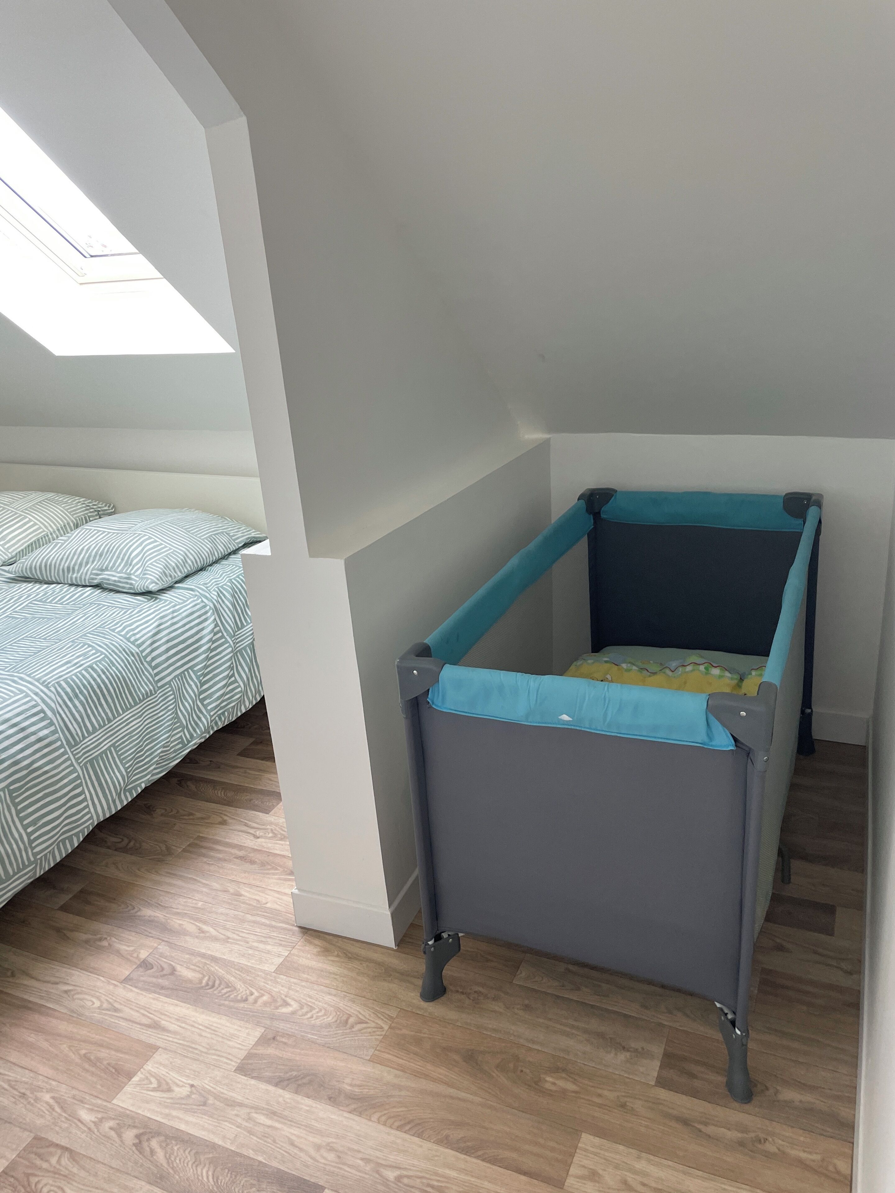 Ein Zimmer mit Etagenbett, einem kleinen Tisch und einem Oberlicht.