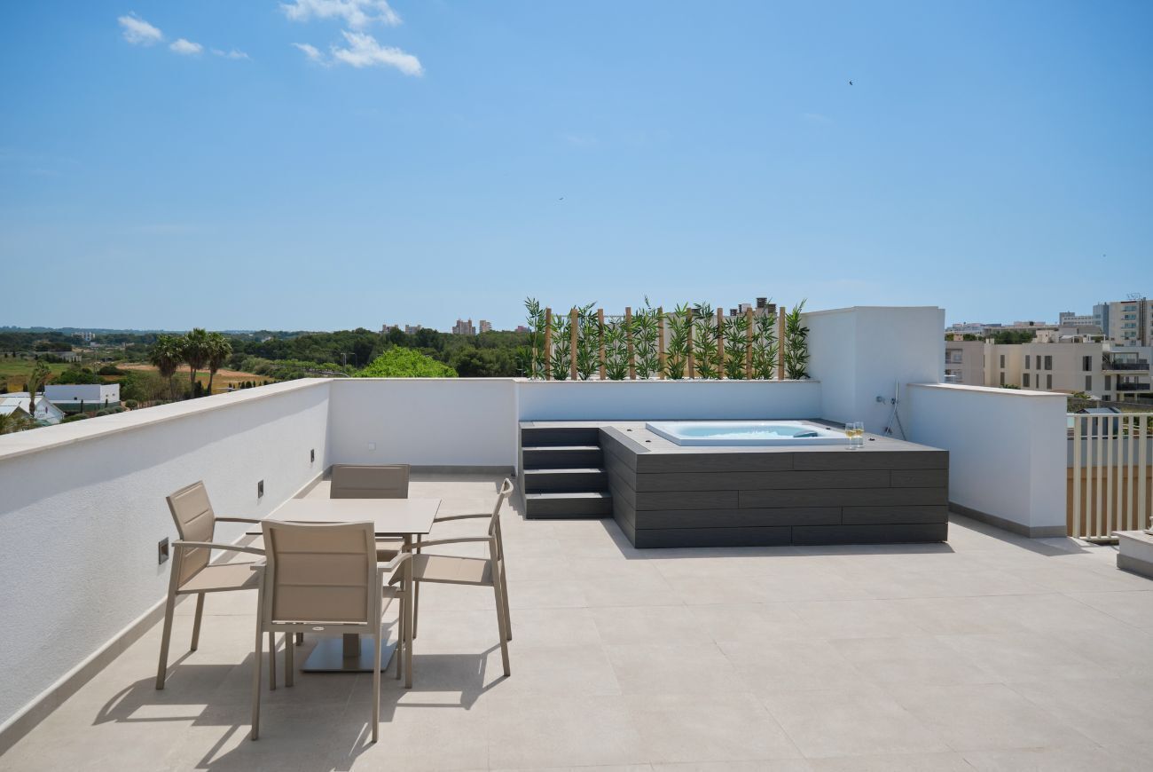 A rooftop terrace with a hot tub, outdoor seating, and a view of the cityscape.