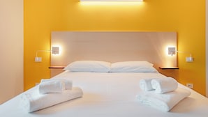Een hotelkamer met een bed, twee nachtkastjes en twee wandlampen.
