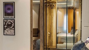 A modern bedroom with a bed, a bench, a wardrobe, and a mirror. - Divine Grace Apartment (Lagos)