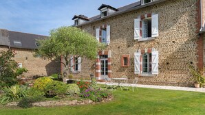 Un bâtiment en pierre doté d’un jardin, d’un espace extérieur aménagé pour s’asseoir et offrant une vue sur un ciel dégagé.