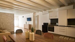Una cucina moderna con mobili bianchi, forno integrato e frigorifero nero.