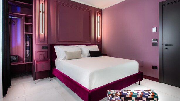 Ein modernes Schlafzimmer mit einem großen Bett, eingebauten Regalen und einer Tür mit einer Sicherheitseinrichtung.