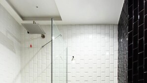 Ein modernes Badezimmer mit Duschkabine aus Glas, einem Standwaschbecken und einer Toilette.