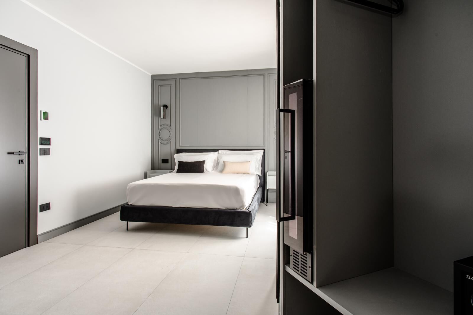 A modern bedroom with a large bed, a wardrobe, and a door.