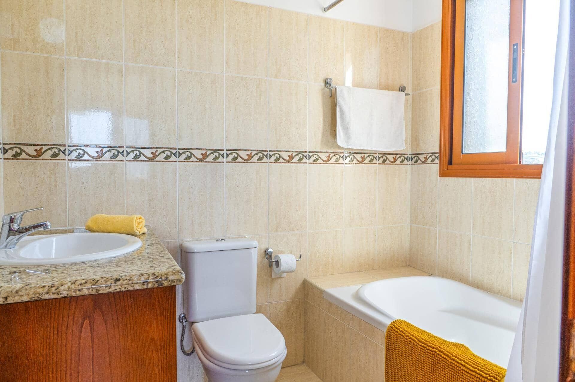 Ein Badezimmer mit Waschbecken, Toilette und Badewanne.