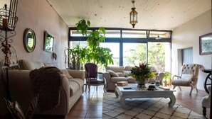 Una sala de estar con un sofá, sillones, una mesa de centro y un ventanal.