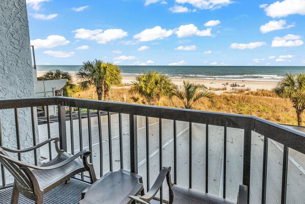 A balcony with a view of the beach and ocean. - Compass Cove Condos (Myrtle Beach)