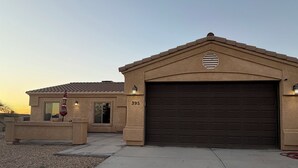 A residential building with a garage, numbered 395, and a small porch area with a red umbrella.