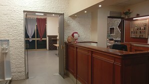 Ein Empfangsbereich mit einem Holzbüro, einem Globus und einem Schlüsselhalter an der Wand.