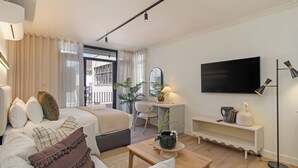 A modern hotel room with a bed, a desk, a TV, and a coffee table. - The York | Designer CBD Retreat (Cape Town)