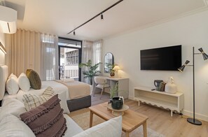 Ein modernes Hotelzimmer mit Bett, Schreibtisch, Fernseher und Couchtisch.